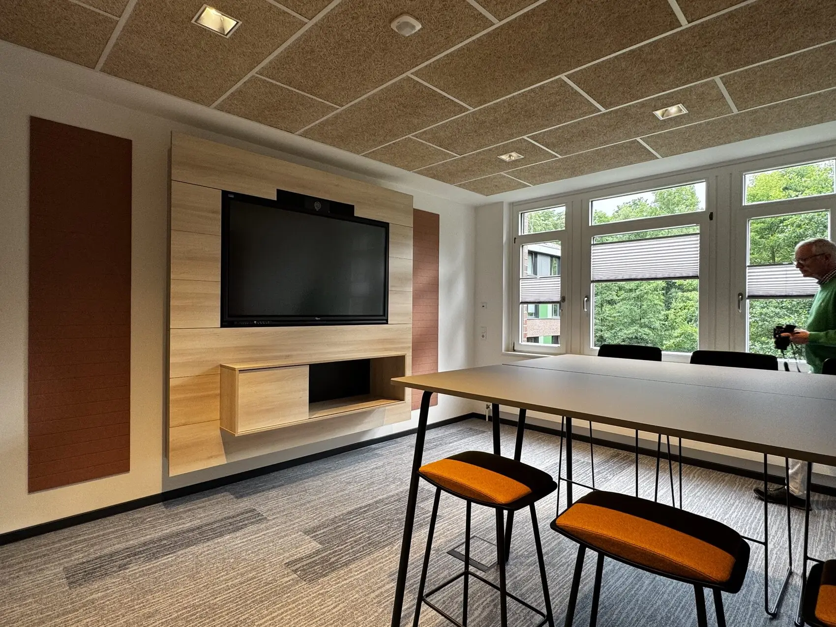 Moderne Betriebsgastronomie mit Hochtischen, Barhockern und Holzwand