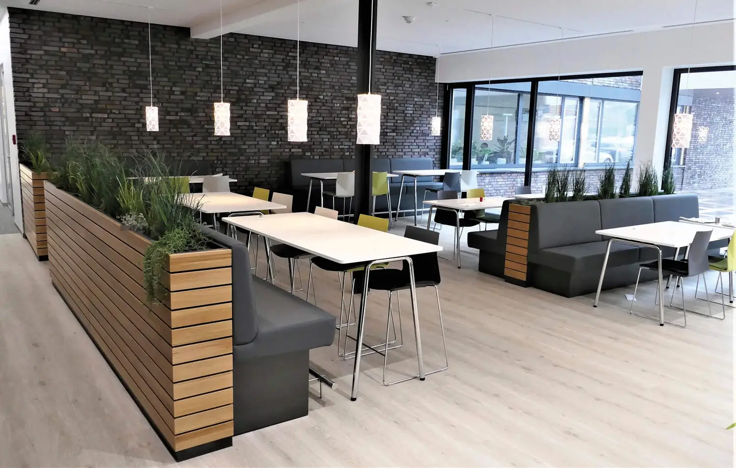 Modernes Betriebsbistro mit Sitznischen und warmer Holzgestaltung