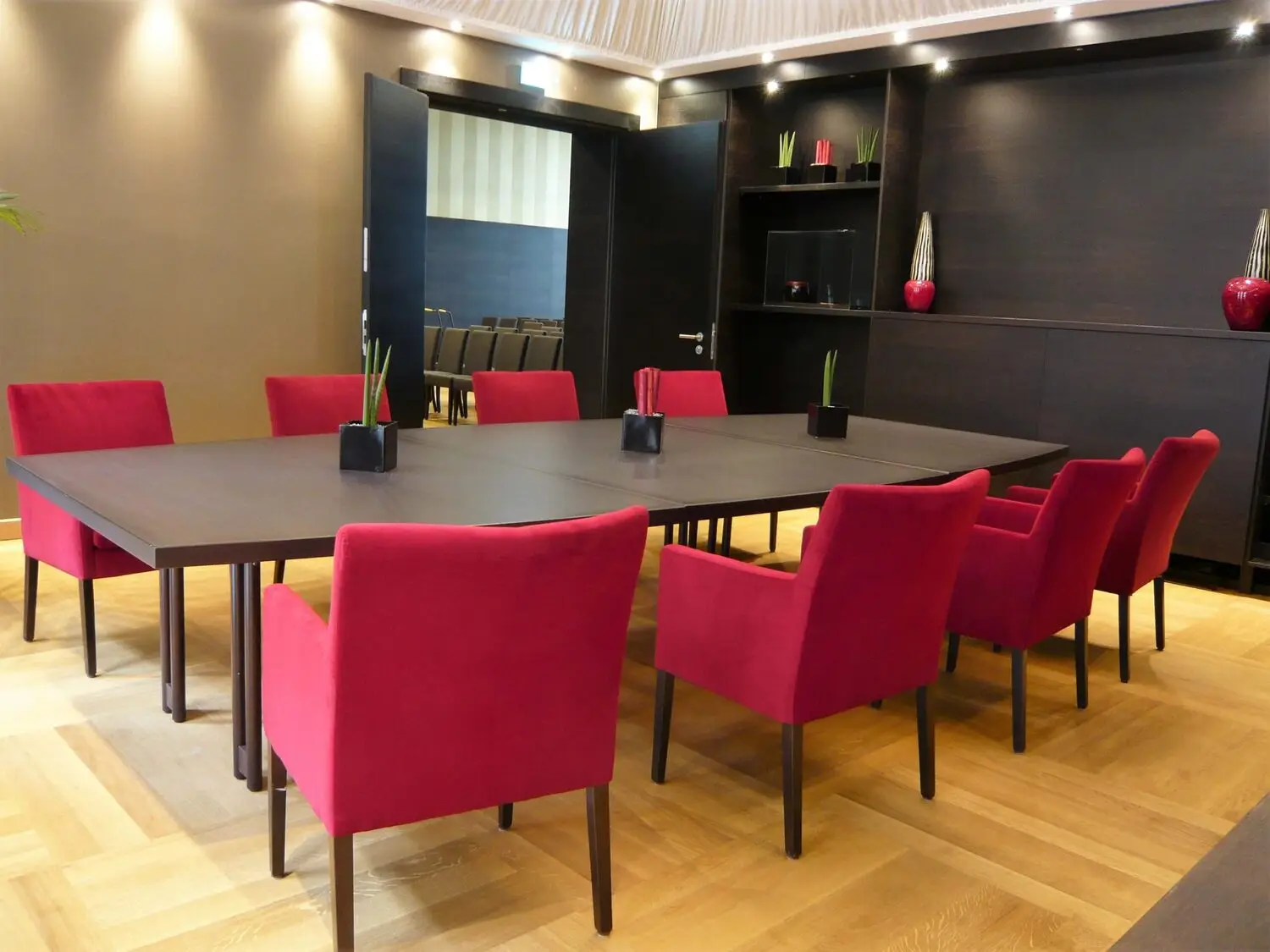 Konferenzbereich mit großem Tisch und farbigen Stühlen