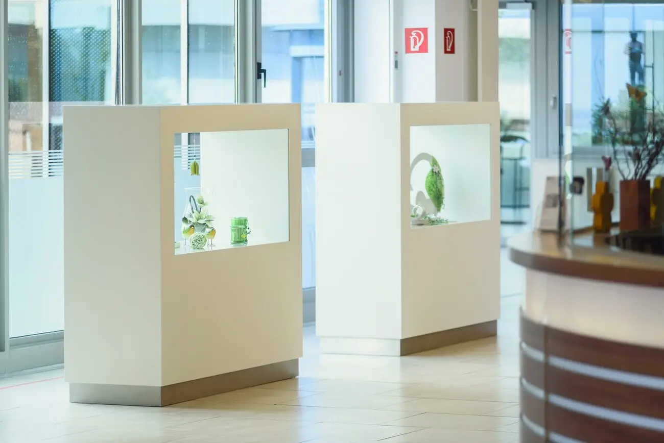 Repräsentativer Empfangsbereich mit beleuchteten Vitrinen und Theke